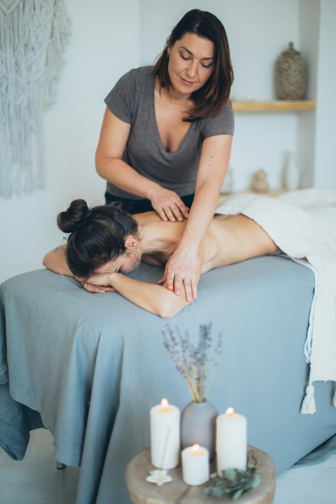 Woman lying on bed while having a massage